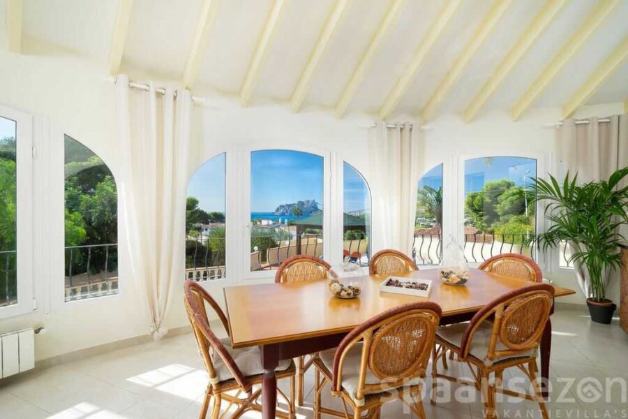 Conservatoire avec une grande table et vue panoramique sur la mer