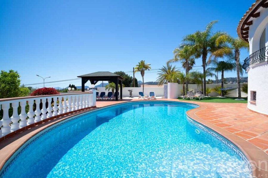 grande piscine avec terrasse spacieuse et chaises longues